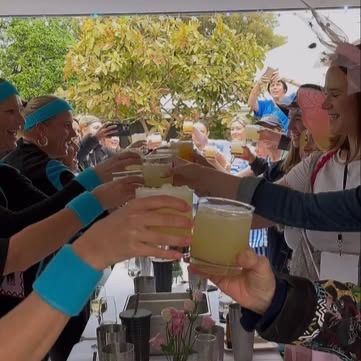 Guests clinking drinks along a long class table